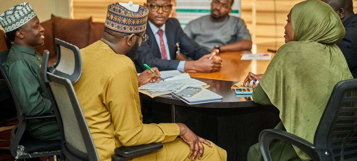 A team meeting around a boardroom table at a Nigerian company