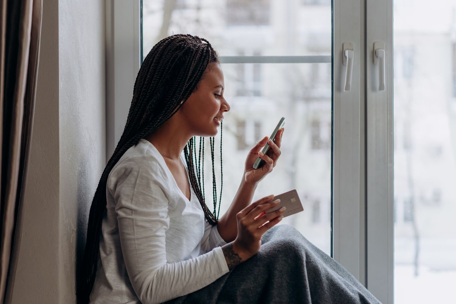 A woman paying on her phone with a card in her hand