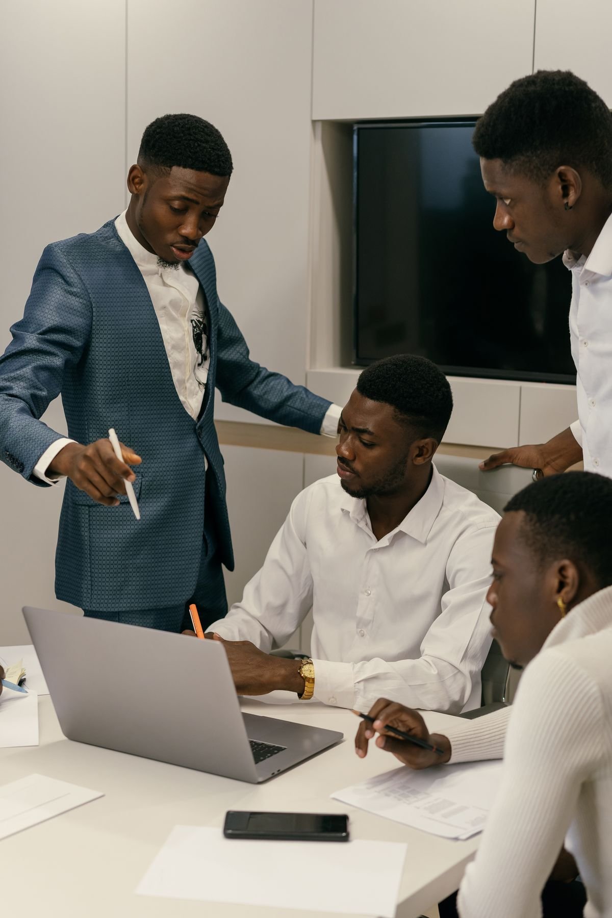 A senior marketer reviewing a team's work on a laptop alongside printed reports